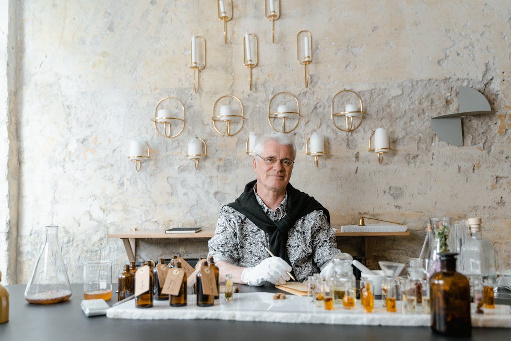 A Man Sitting in front of Perfume Bottles