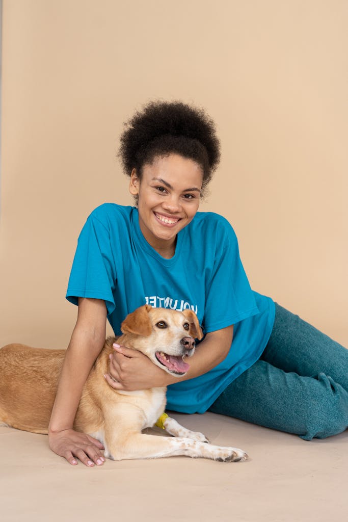 A Smiling Woman Sitting on the Floor with a Dog