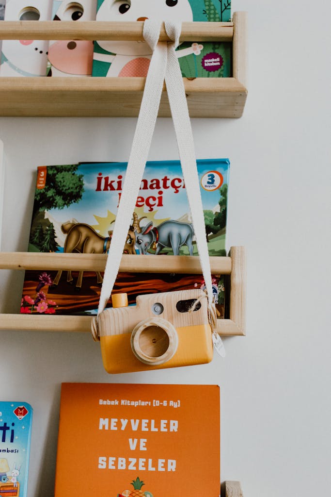 A Wooden Toy Camera Hanging on a Wooden Shelf in a Baby's Room