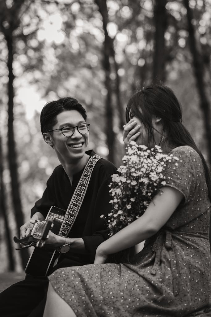 Asian couple with guitar in park