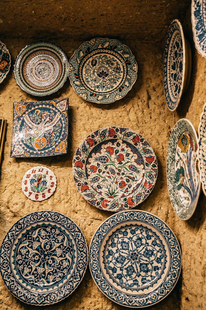 Ceramic decorative handmade plates with various ornaments hanging on stone wall in Morocco