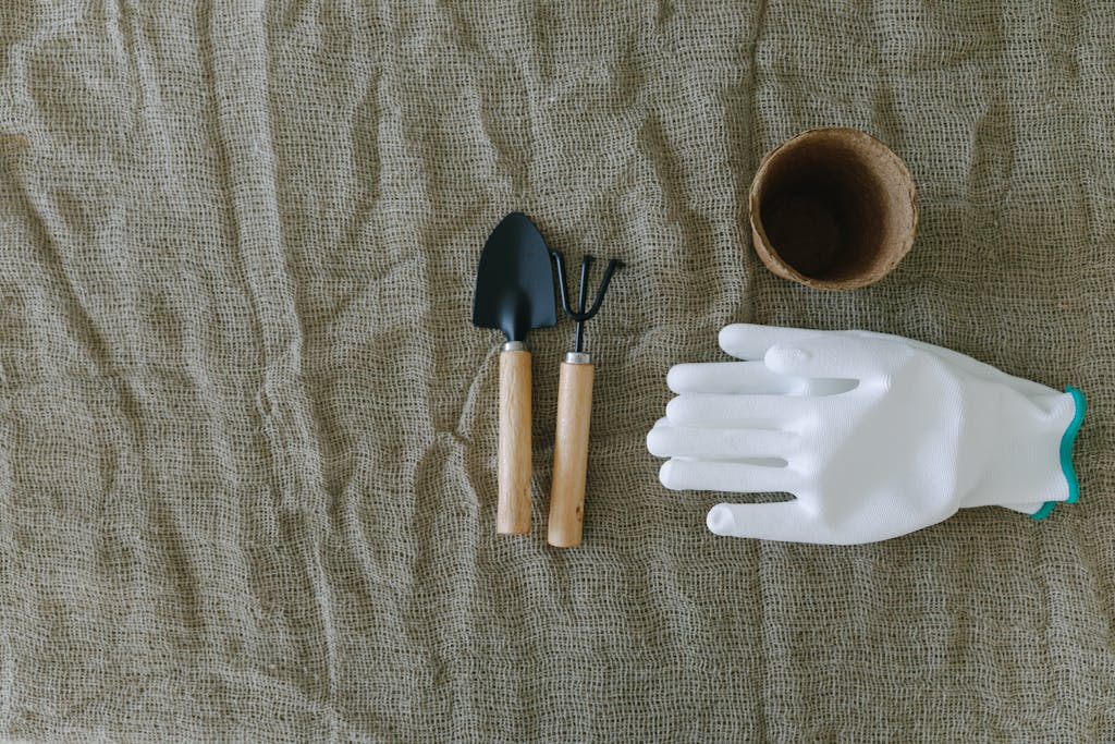Gardening Tools and Gloves over a Woven Fabric