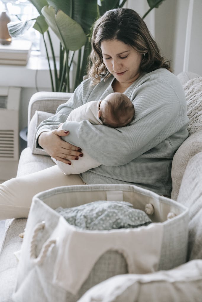 Mother with newborn baby on couch
