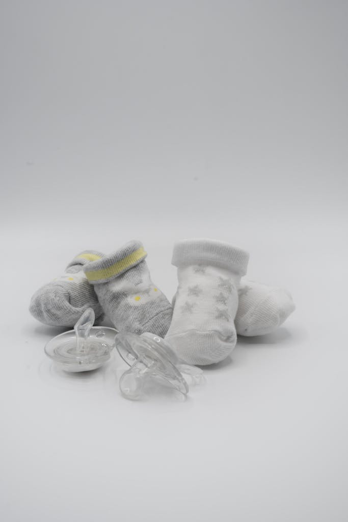 Pair of Socks and Pacifiers on White Surface