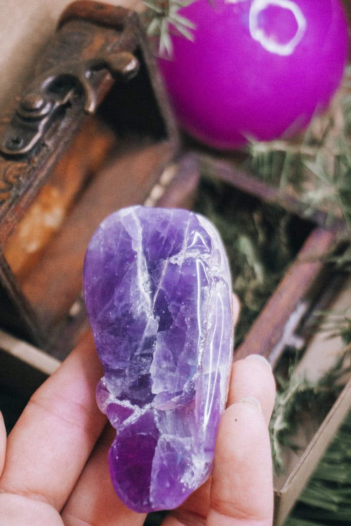 Person showing natural Amethyst against stylish box