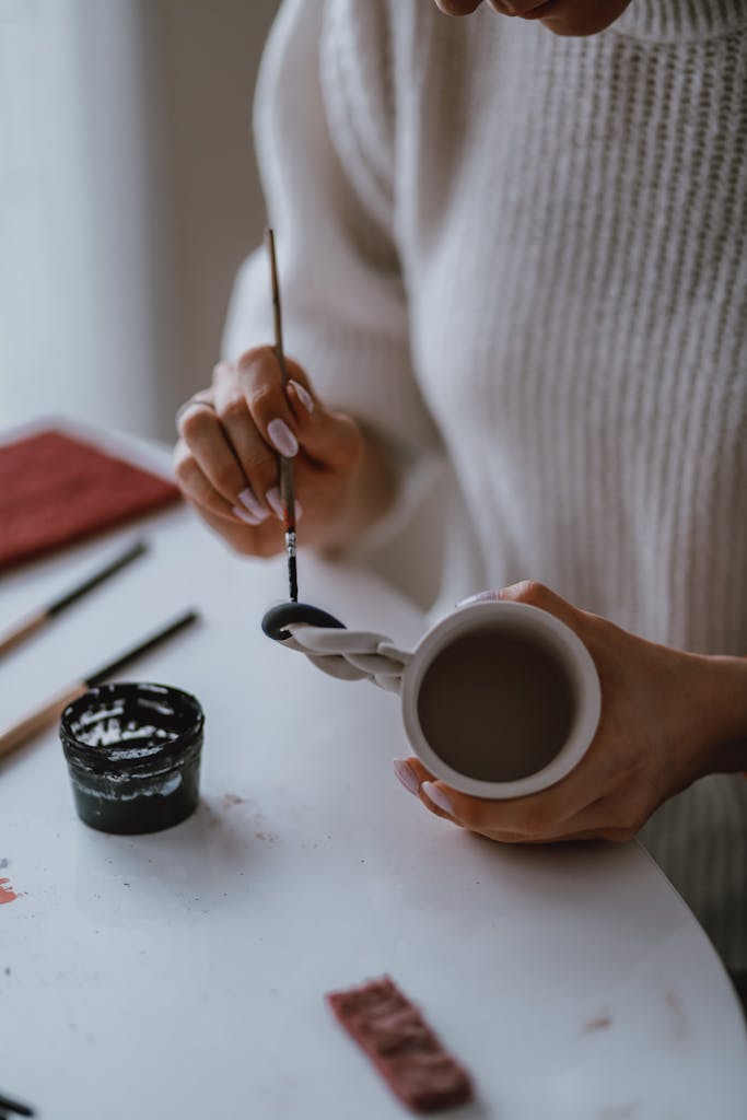 Photo of a Person Painting a Mug