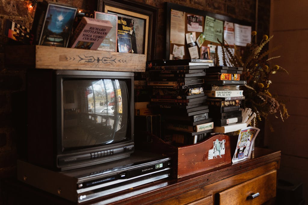 Photo of a Vintage TV, DVD Player, Tapes and Cassettes on a Vintage Cabinet