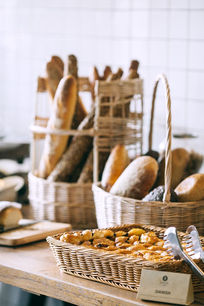 Tasty fresh homemade baguette placed in wicker basket and fresh baked pies in bakery in daytime