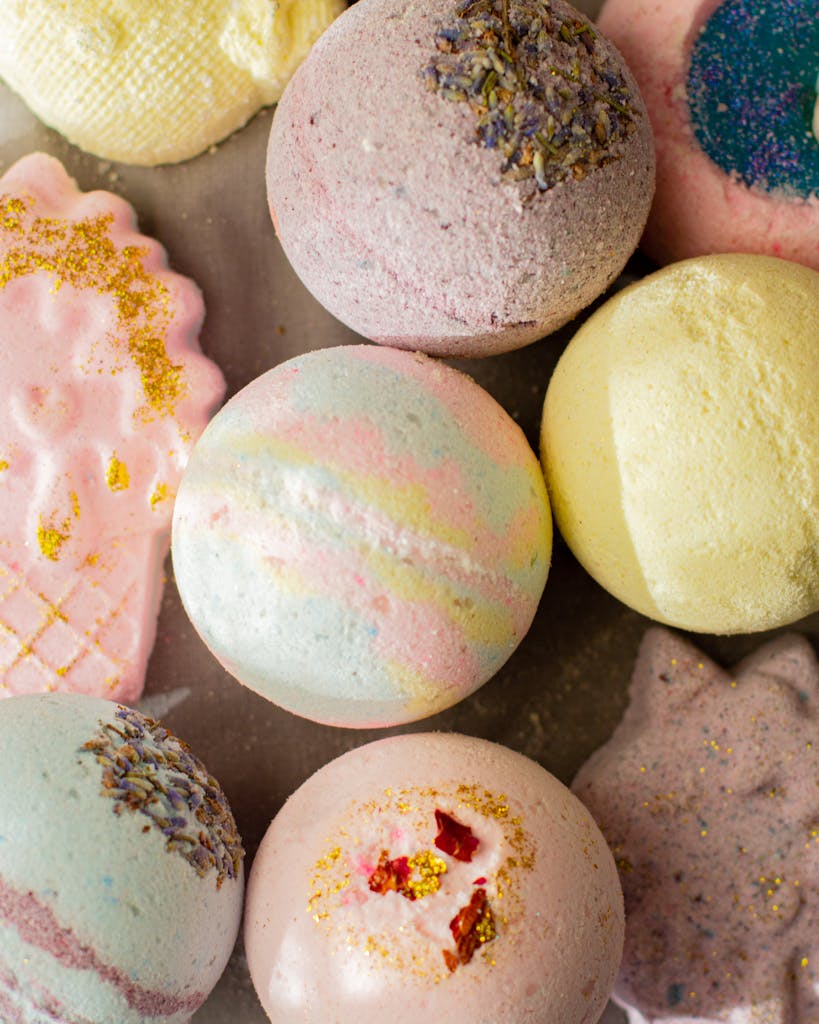 Top view composition of aromatic pastel bath bombs in different shapes arranged on table in light bathroom