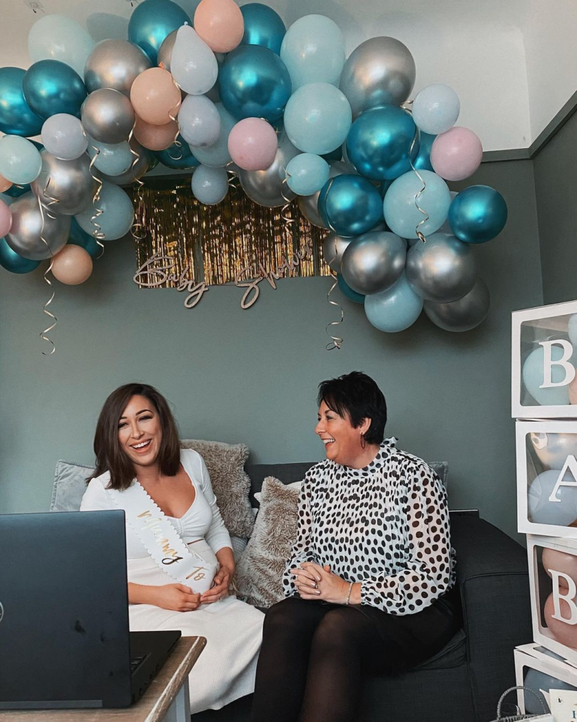 a woman enjoying a virtual baby shower event, another woman is there by her side
