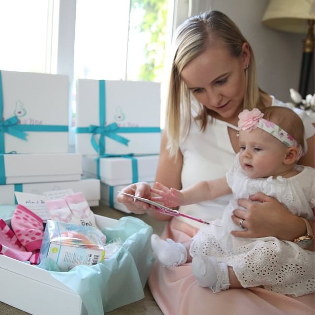 a mother with her baby checking out a subscription box